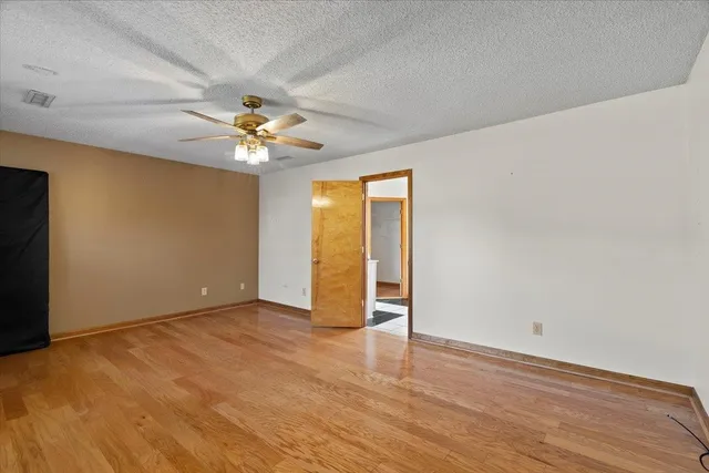 an empty room with closet and a ceiling fan