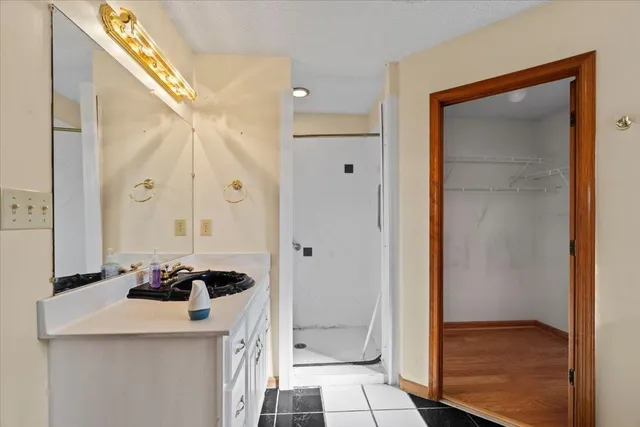 an empty room with windows and chandelier fan