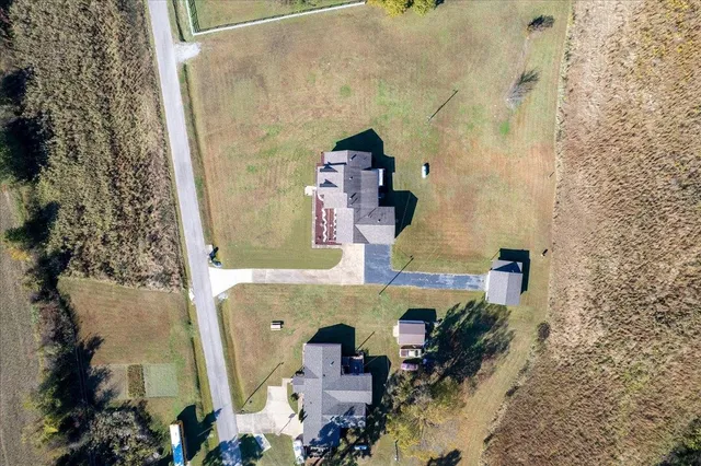 an aerial view of a house with a yard and large tree