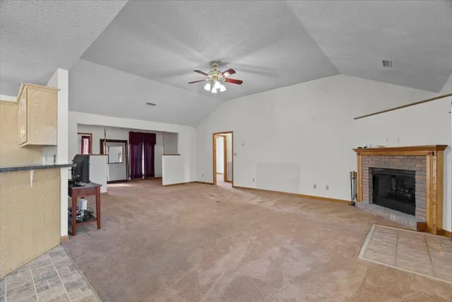 an empty room with windows and fireplace