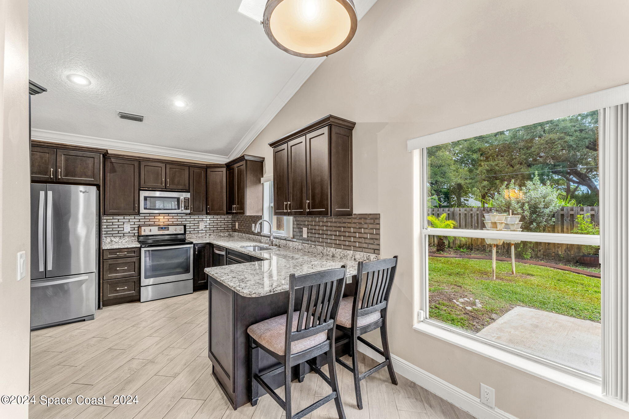 431 Nina Road Northeast Palm Bay, FL 32907 - Photo 14 of 41 a kitchen with a table chairs refrigerator and cabinets