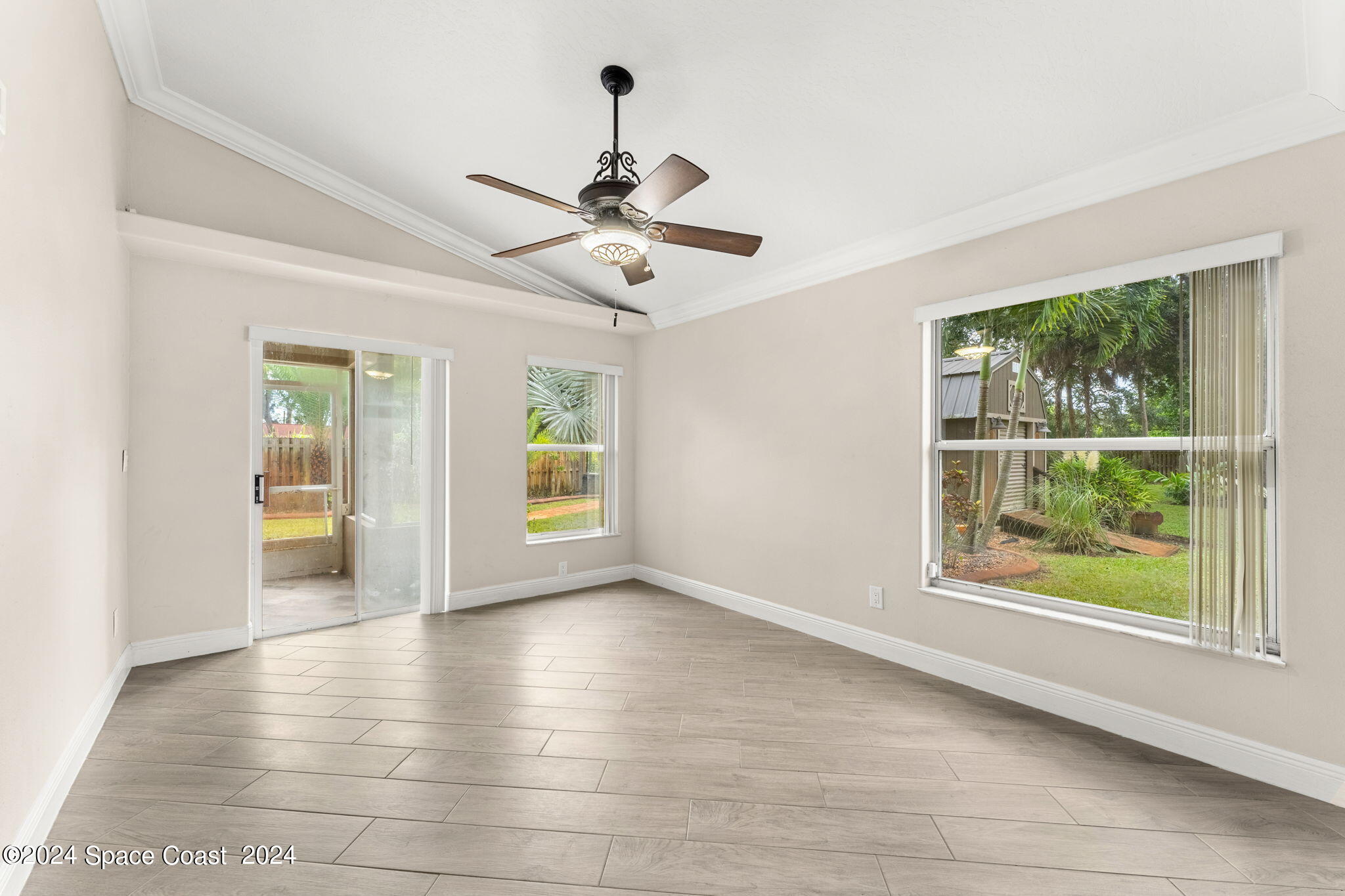 431 Nina Road Northeast Palm Bay, FL 32907 - Photo 15 of 41 a view of an empty room with a window and wooden floor