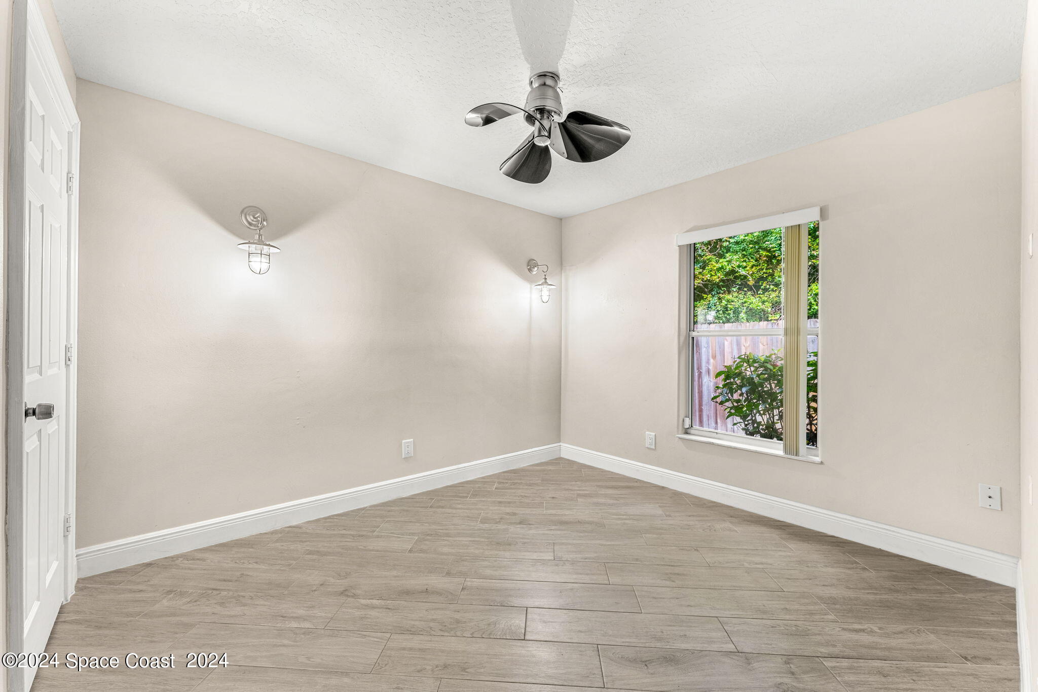 431 Nina Road Northeast Palm Bay, FL 32907 - Photo 19 of 41 wooden floor in an empty room with a window