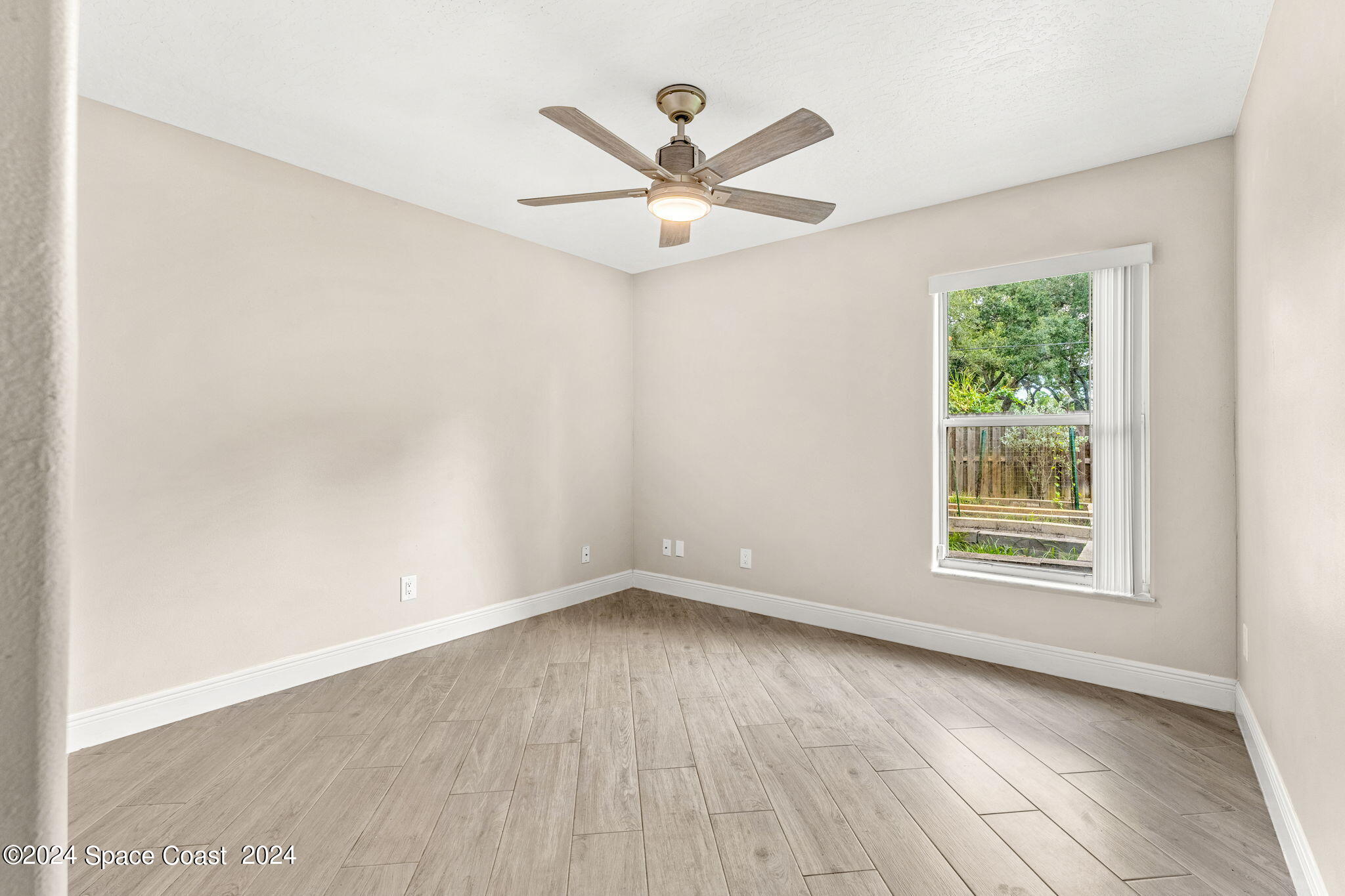 431 Nina Road Northeast Palm Bay, FL 32907 - Photo 20 of 41 wooden floor in an empty room with a window