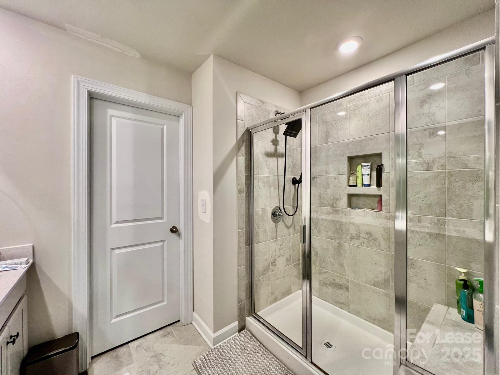 11509 Corleone Street Huntersville, NC 28078 - Photo 11 of 21 a bathroom with a glass shower door