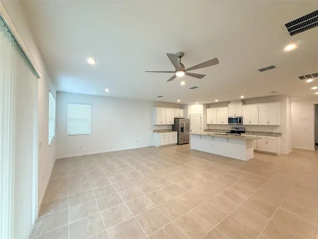 a view of kitchen with kitchen island stainless steel appliances counter space and a sink