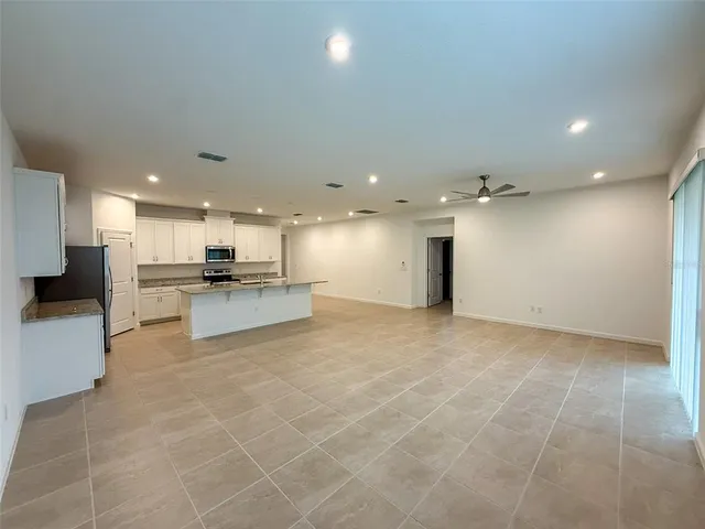 a view of kitchen with kitchen island white cabinets and stainless steel appliances