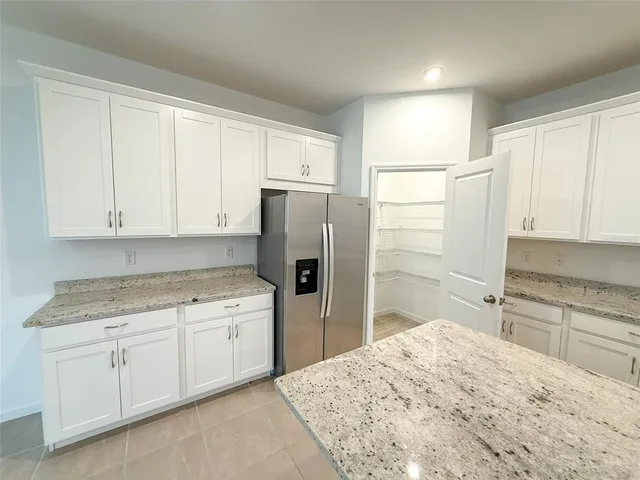 a kitchen with a refrigerator sink and cabinets