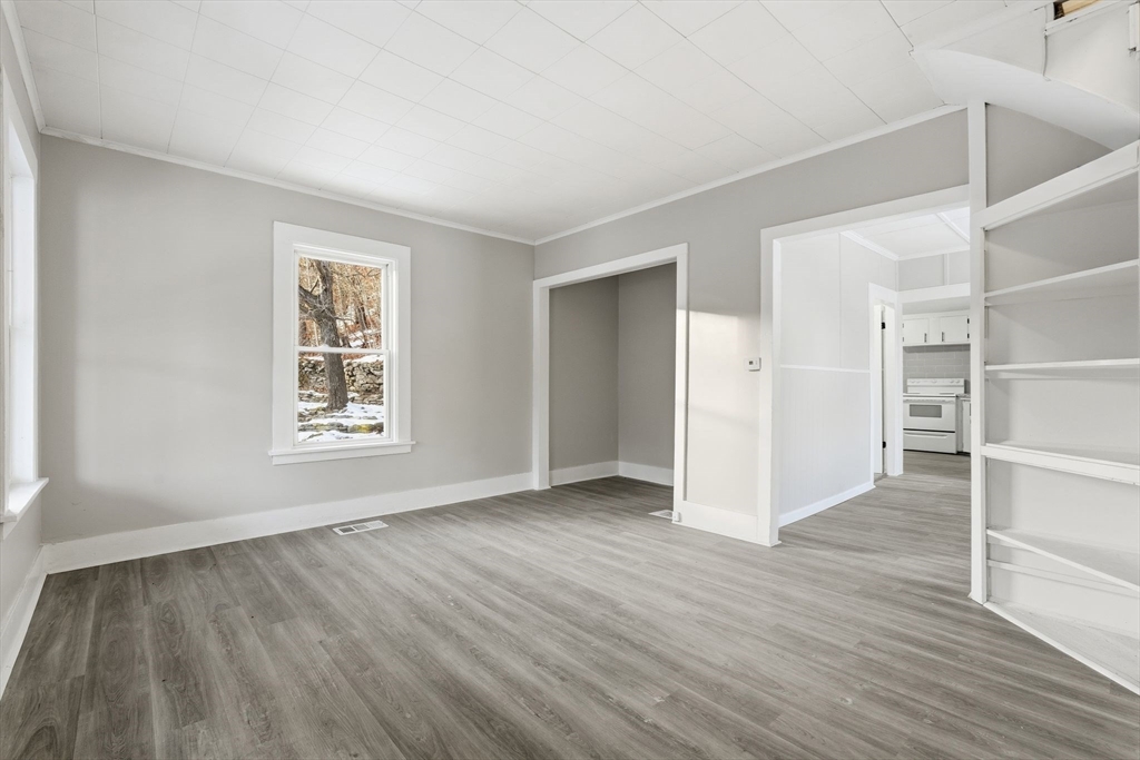62 East Main Street Erving, MA 01344 - Photo 3 of 23 an empty room with wooden floor closet and windows