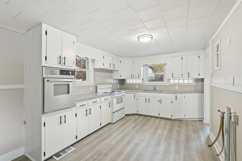 62 East Main Street Erving, MA 01344 - Photo 8 of 23 a kitchen with granite countertop white cabinets and white appliances