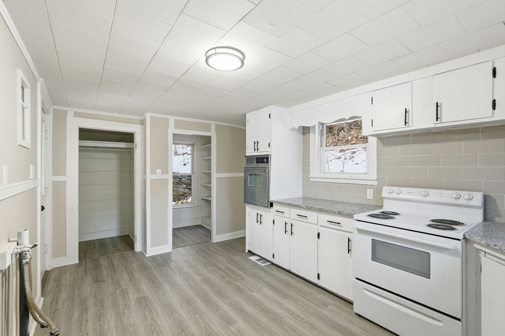 62 East Main Street Erving, MA 01344 - Photo 10 of 23 a kitchen with a stove oven and white cabinets