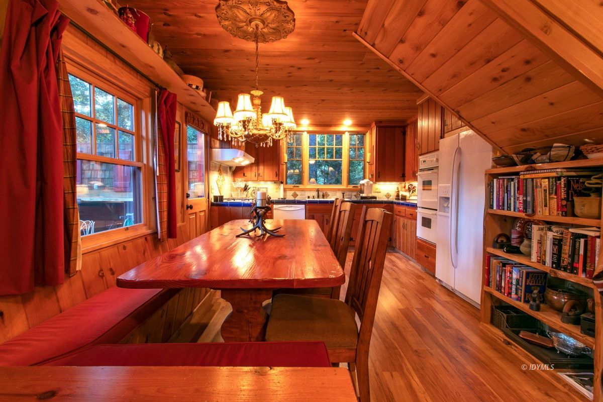 24715 Upper Rim Rock Road Idyllwild, CA 92549 - Photo 21 of 64 a view of a dining room with furniture and a book shelf