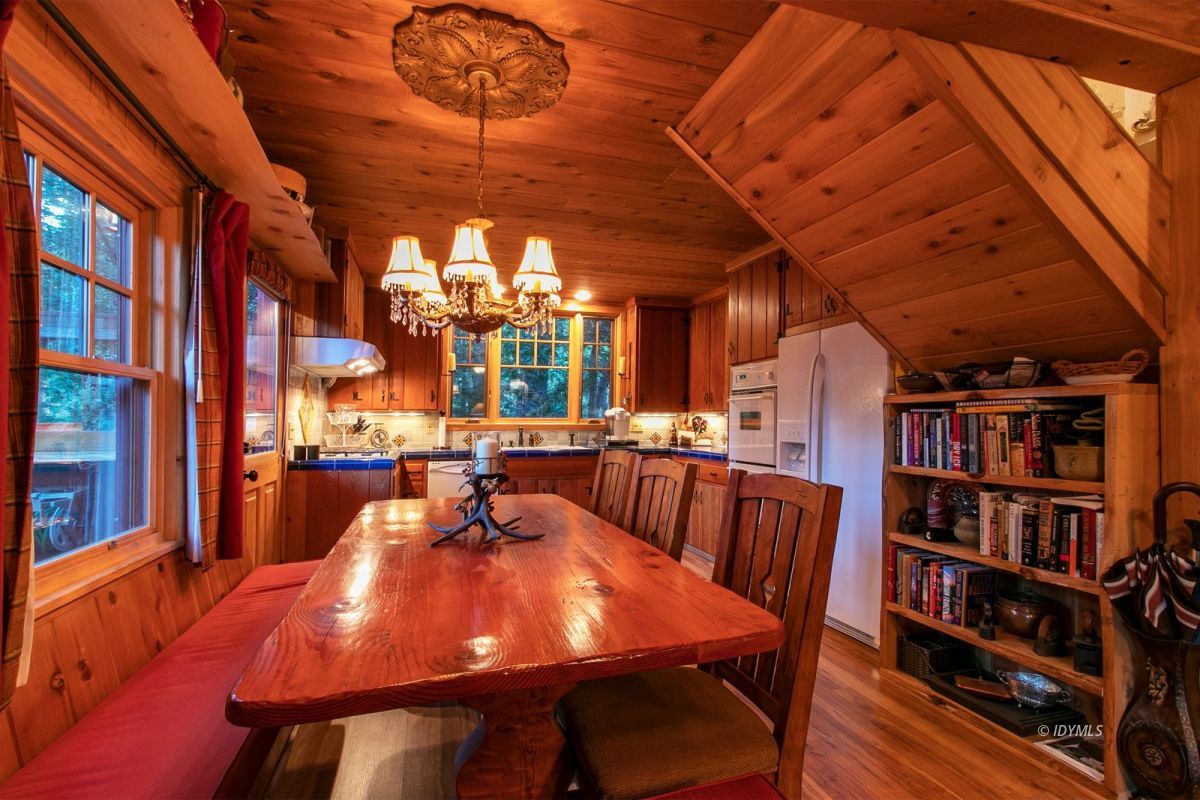 24715 Upper Rim Rock Road Idyllwild, CA 92549 - Photo 22 of 64 a dining room with furniture and a book shelf