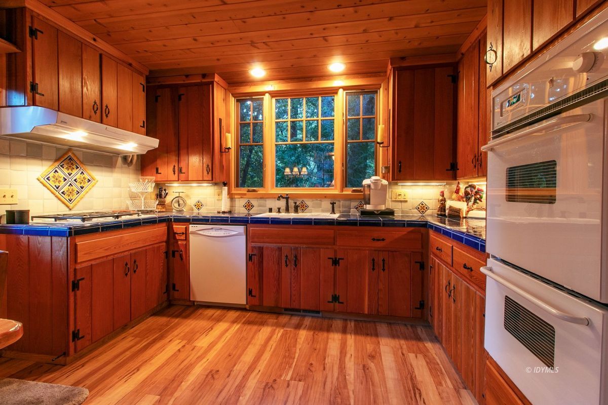 24715 Upper Rim Rock Road Idyllwild, CA 92549 - Photo 23 of 64 a kitchen with stainless steel appliances granite countertop wooden cabinets a sink and a stove