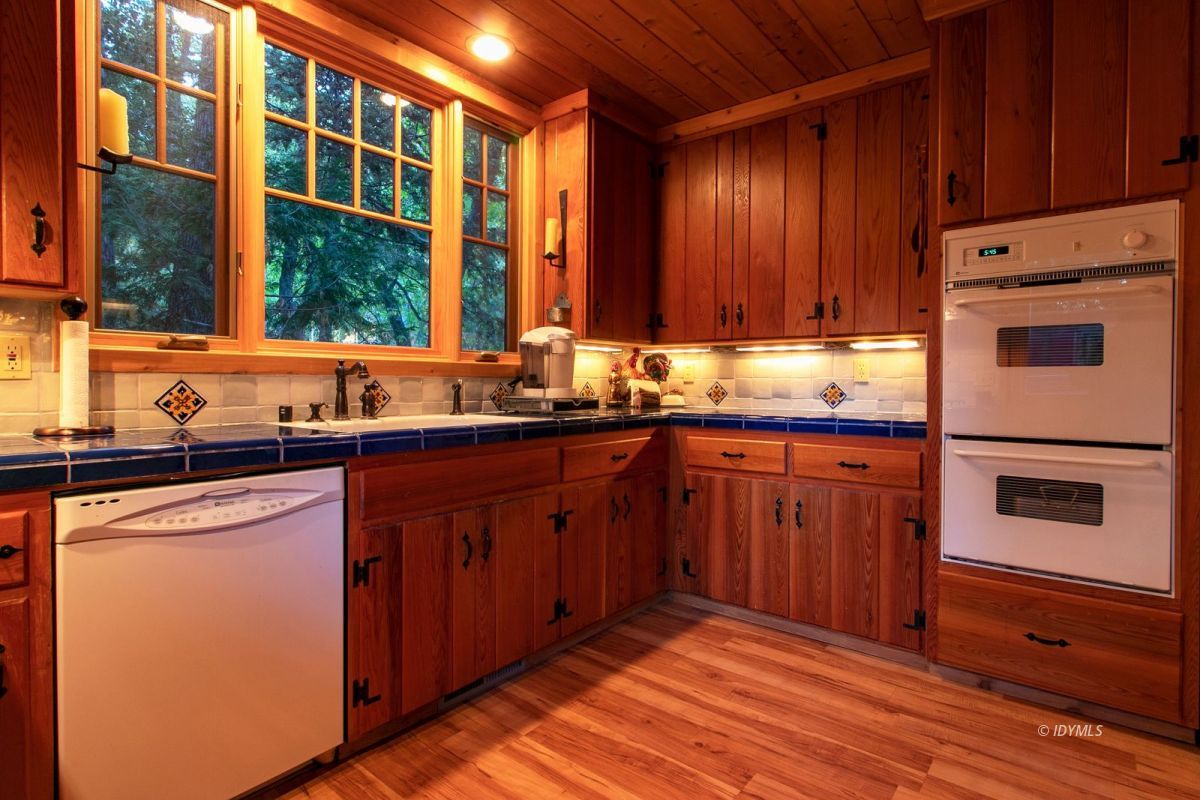 24715 Upper Rim Rock Road Idyllwild, CA 92549 - Photo 27 of 64 a kitchen with stainless steel appliances granite countertop wooden cabinets a sink and a window