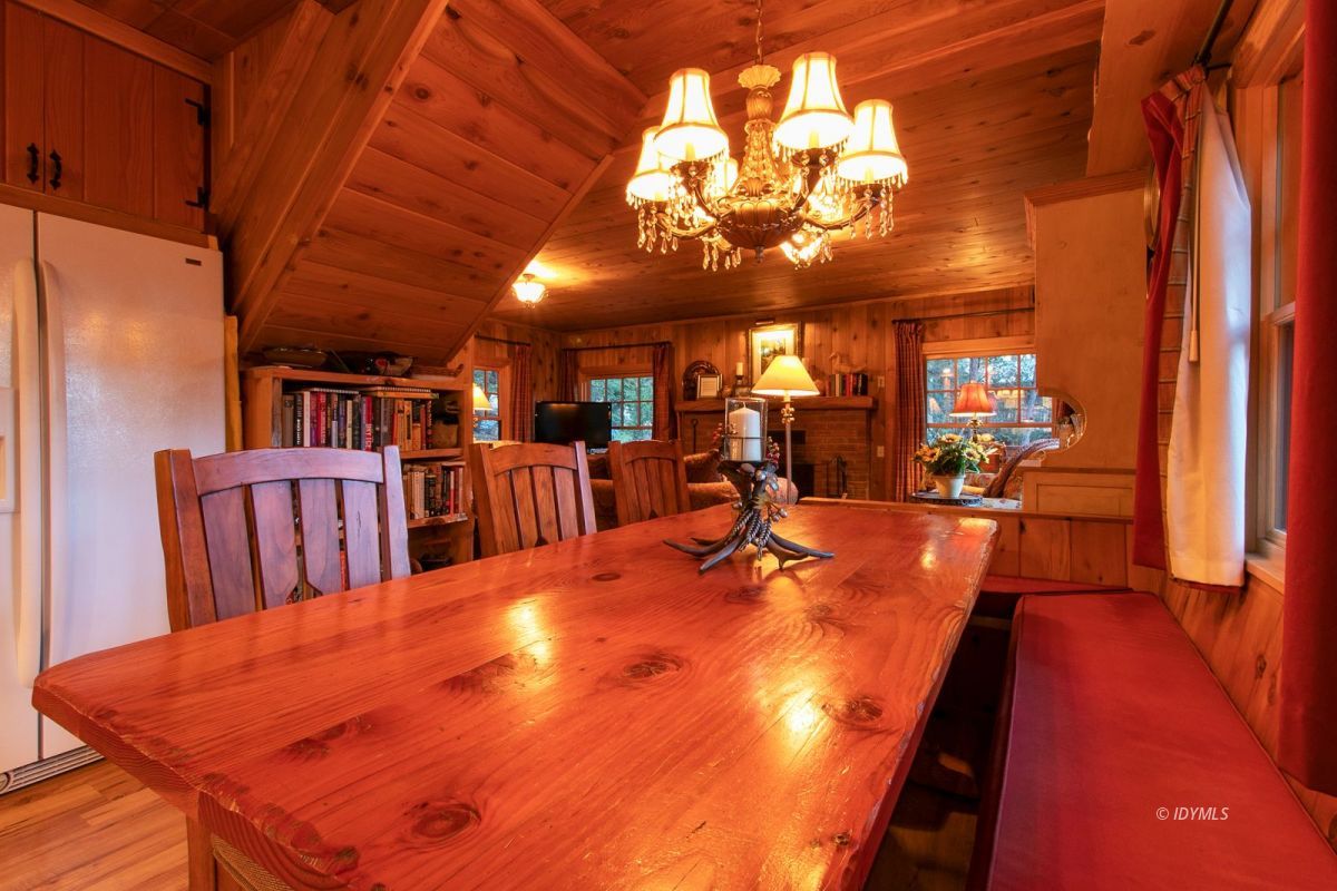 24715 Upper Rim Rock Road Idyllwild, CA 92549 - Photo 29 of 64 a view of a dining room with furniture a chandelier and wooden floor