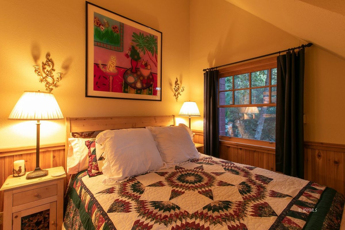 24715 Upper Rim Rock Road Idyllwild, CA 92549 - Photo 44 of 64 a bedroom with a bed and a painting on the wall