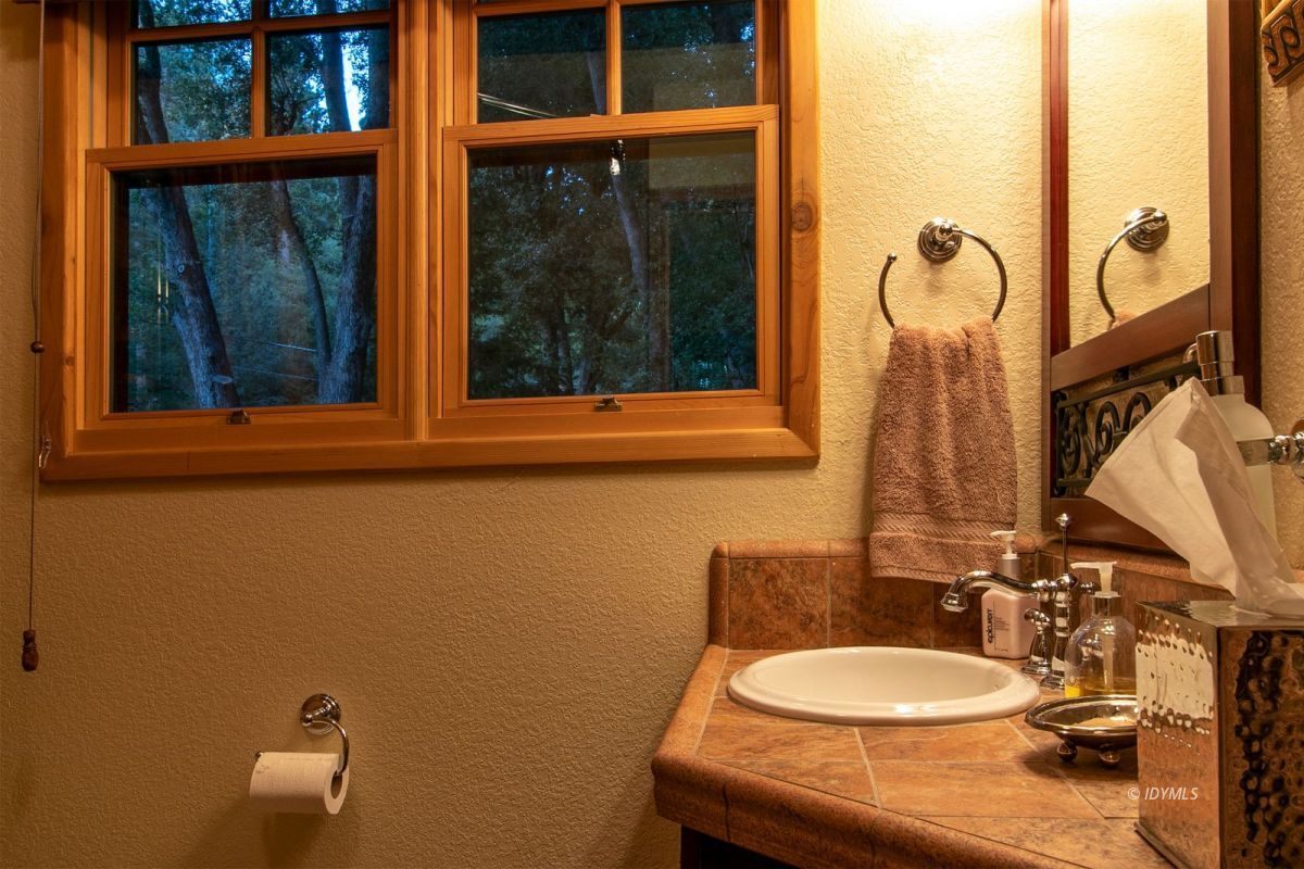 24715 Upper Rim Rock Road Idyllwild, CA 92549 - Photo 47 of 64 a bathroom with a sink mirror and toilet