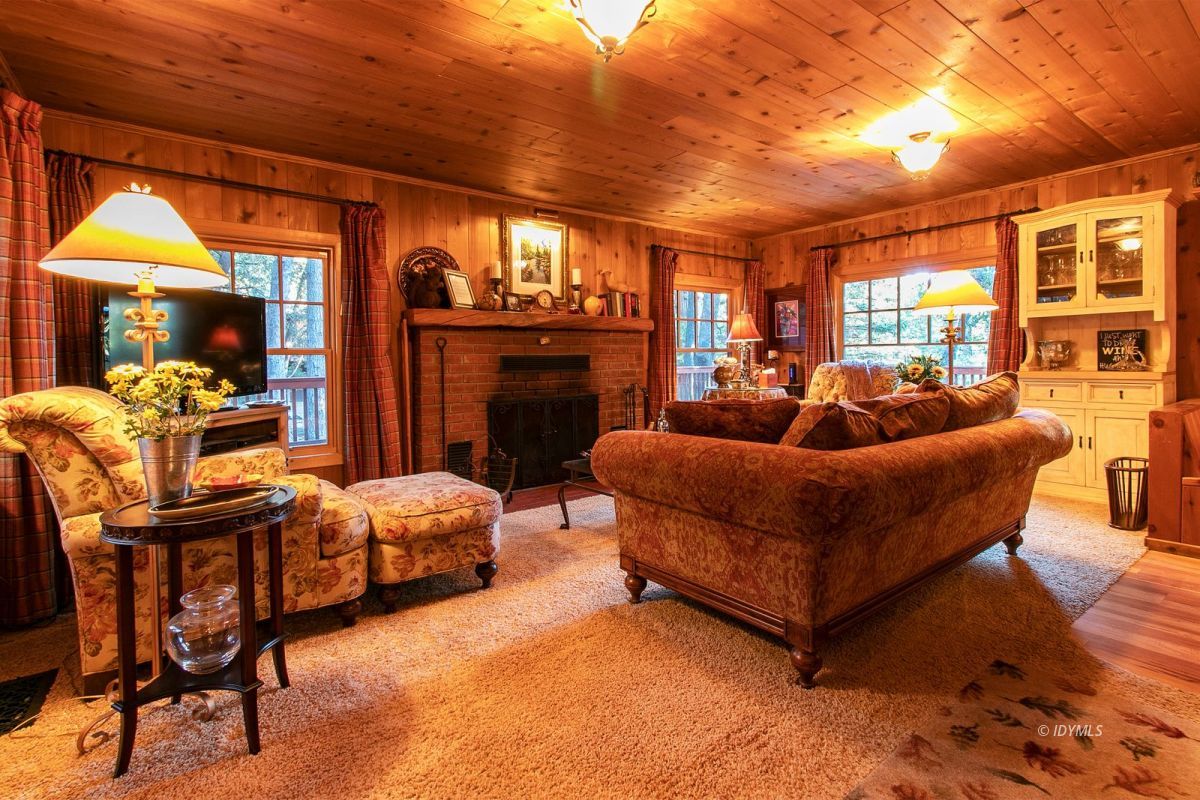 24715 Upper Rim Rock Road Idyllwild, CA 92549 - Photo 10 of 64 a living room with furniture a fireplace and a dining table with wooden floor