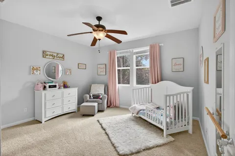 a bedroom with baby bed and baby crib