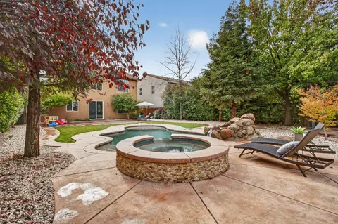 a view of a house with swimming pool and a yard