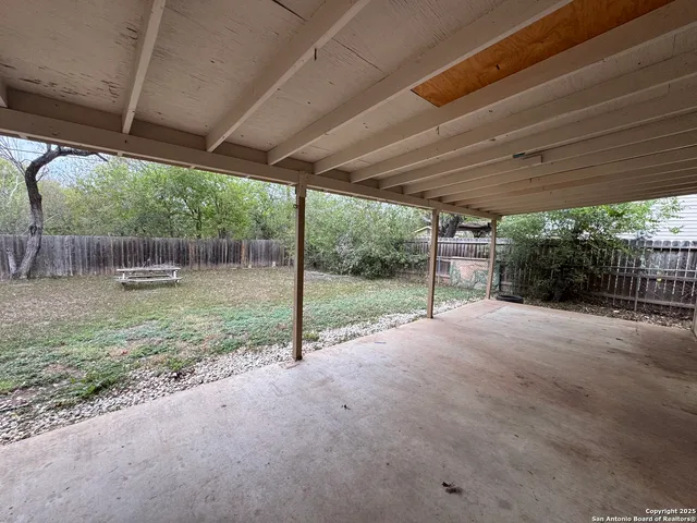 a view of a backyard with floor to ceiling window and tree