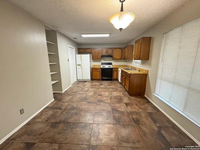 a view of a kitchen with a sink and a refrigerator