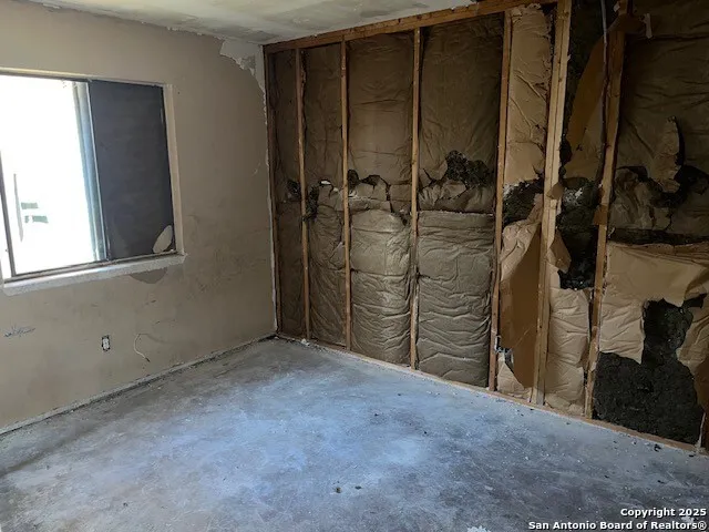 a room with water heater and a wooden cabinets