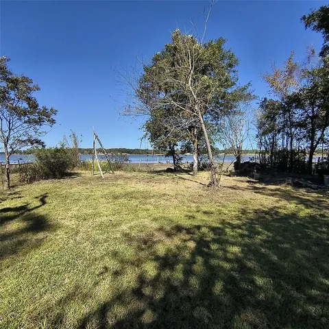 a view of a yard with wooden fence