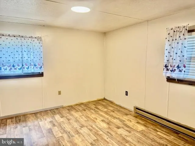 a view of a room with wooden floor and a bathroom
