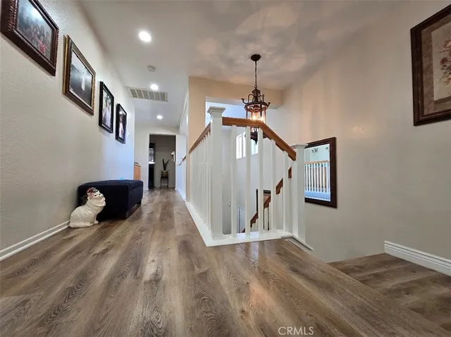 a view of a hallway with stairs and wooden floor