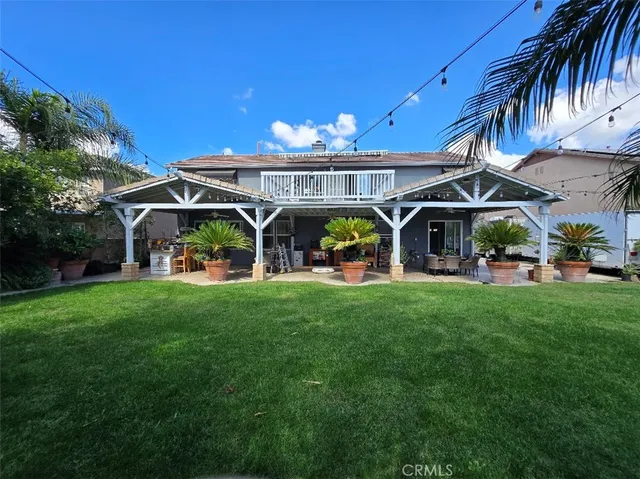 a view of a yard with table and chairs under an umbrella
