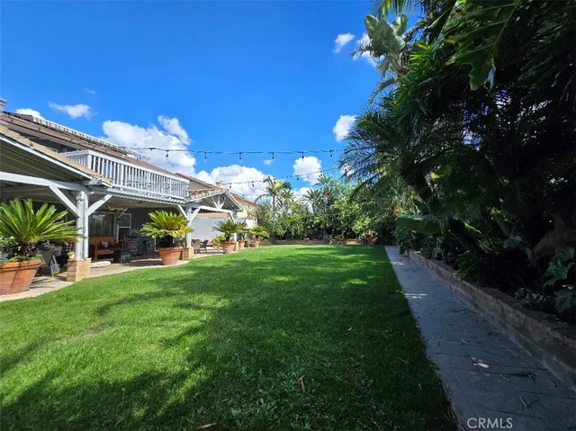 a view of a yard with plants and a fountain