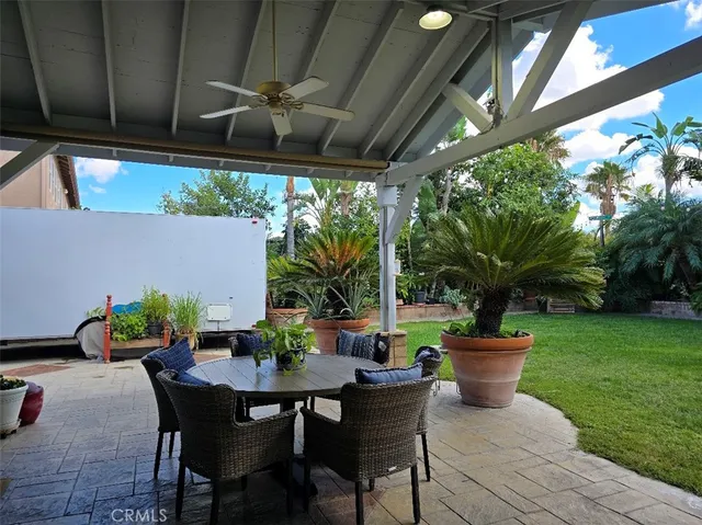a view of a patio with table and chairs potted plants with wooden fence