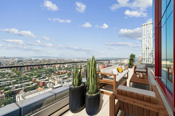 a view of a balcony with chairs and a floor to ceiling window