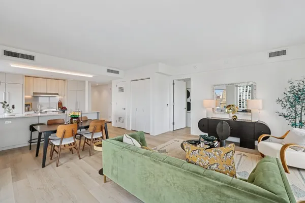 a living room with furniture and a dining table with wooden floor