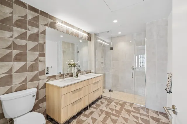 a bathroom with a double vanity sink toilet and shower