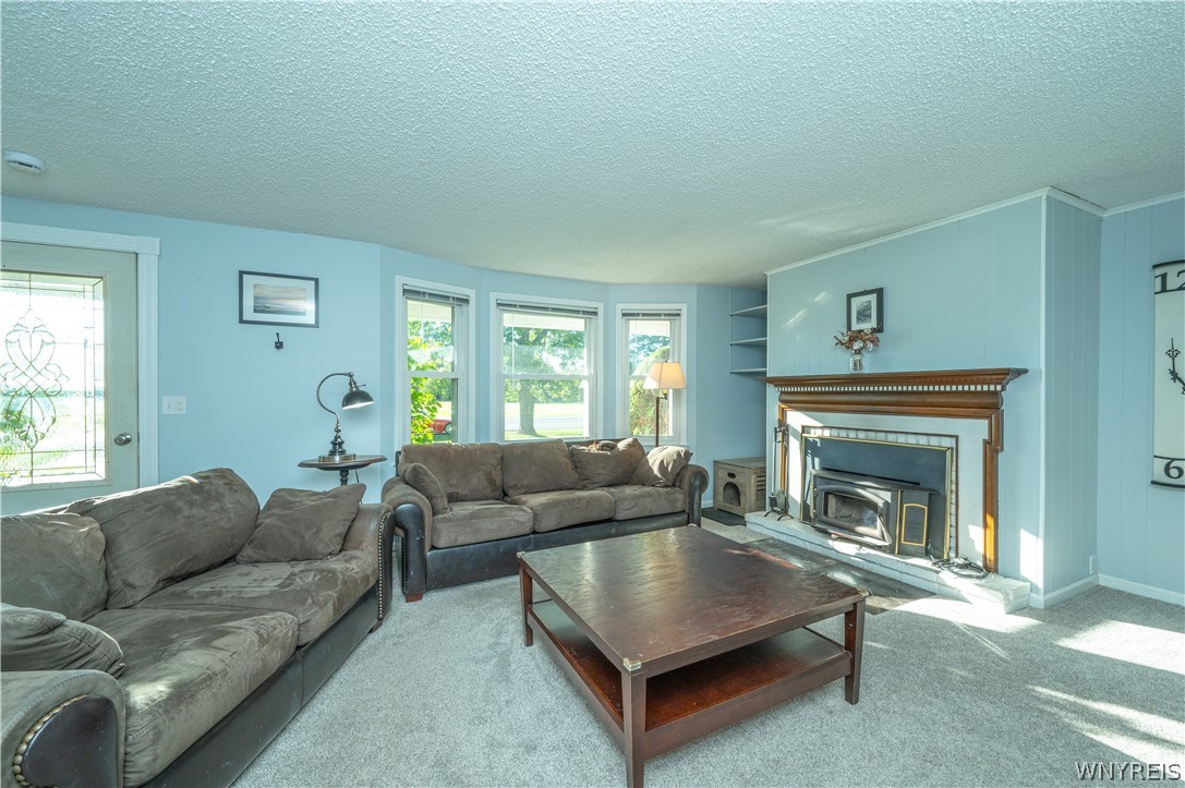 6463 Ward Road Sanborn, NY 14132 - Photo 11 of 49 An inviting fireplace serves as the centerpiece of this comfortable living space.