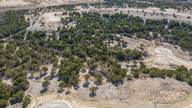an aerial view of residential house with space and trees all around