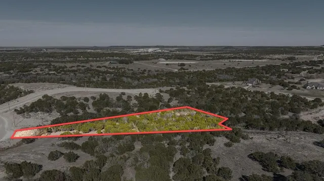an aerial view of a house with a yard and lake view
