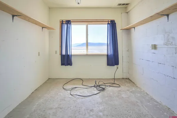 a view of an empty room with window and closet