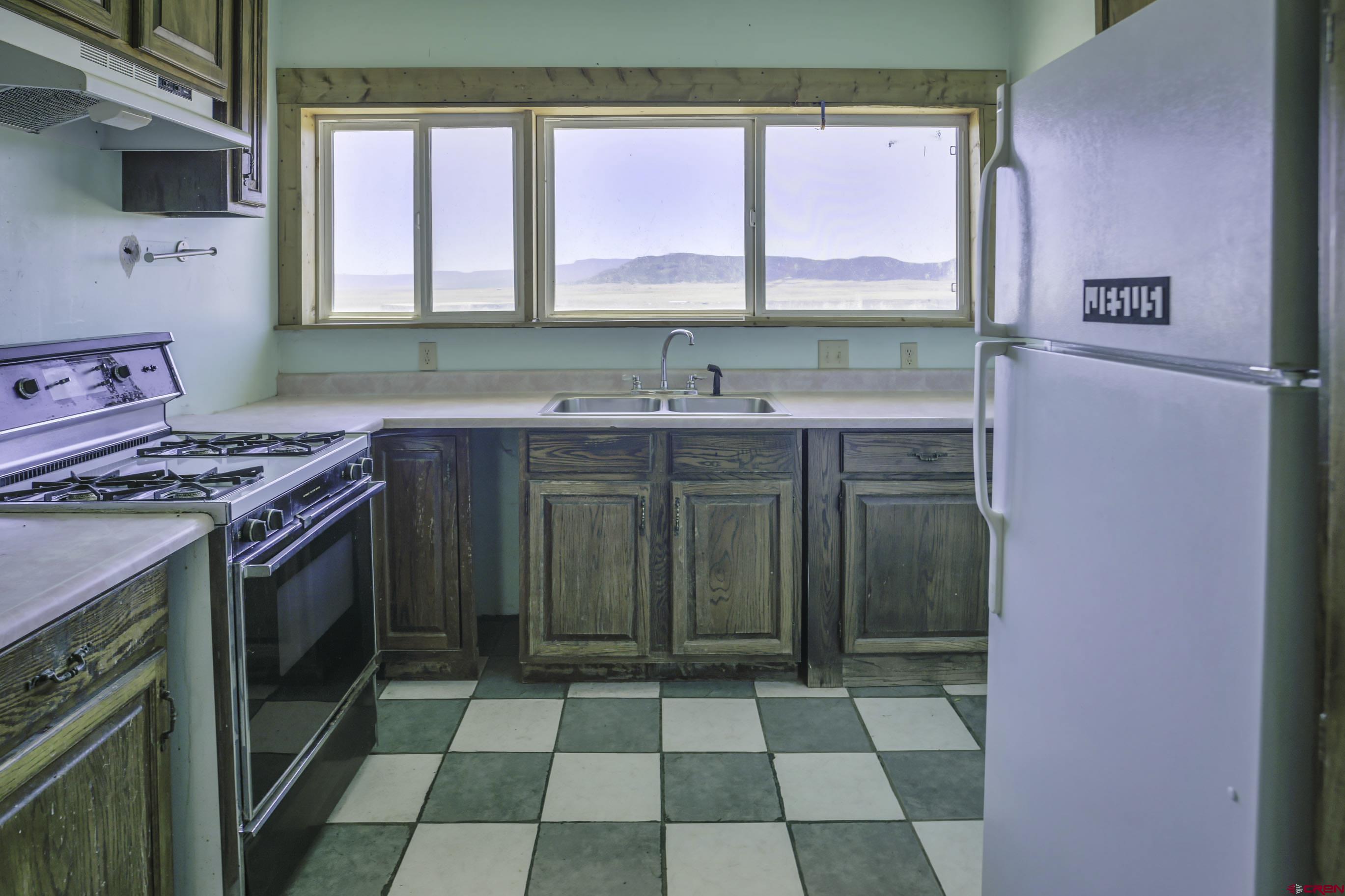 23500 Ridge Road Trinidad, CO 81082 - Photo 9 of 42 a kitchen with a sink a stove top oven cabinets and a window