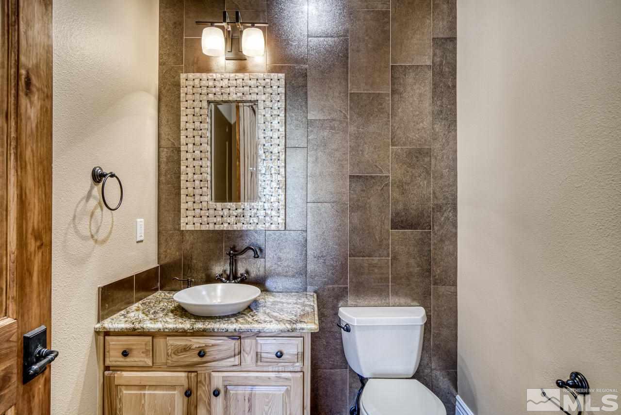 10049 Casazza Ranch Lane Reno, NV 89511 - Photo 11 of 40 a bathroom with a granite countertop toilet sink and mirror