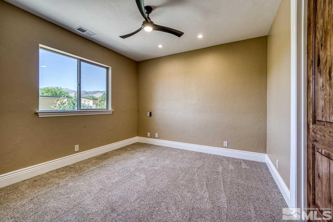 10049 Casazza Ranch Lane Reno, NV 89511 - Photo 24 of 40 en empty room with windows and ceiling fan