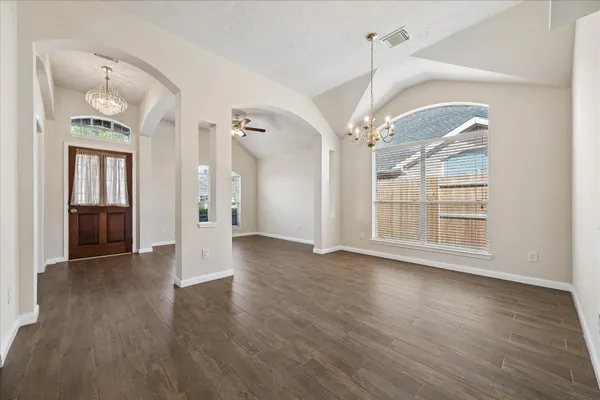 a view of a big room with wooden floor staircase and a kitchen
