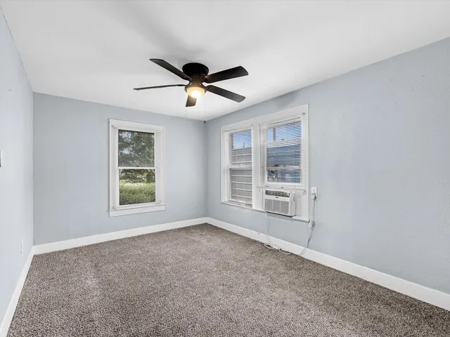 a room with ceiling fan and window