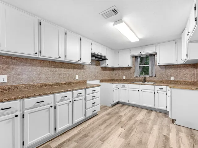 a kitchen with granite countertop white cabinets white stainless steel appliances with a sink and dishwasher