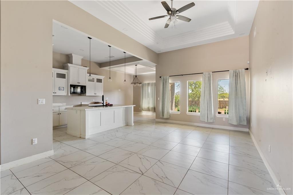 822 Whitewing Street Alamo, TX 78516 - Photo 2 of 11 a large white kitchen with cabinets a sink a window and stainless steel appliances
