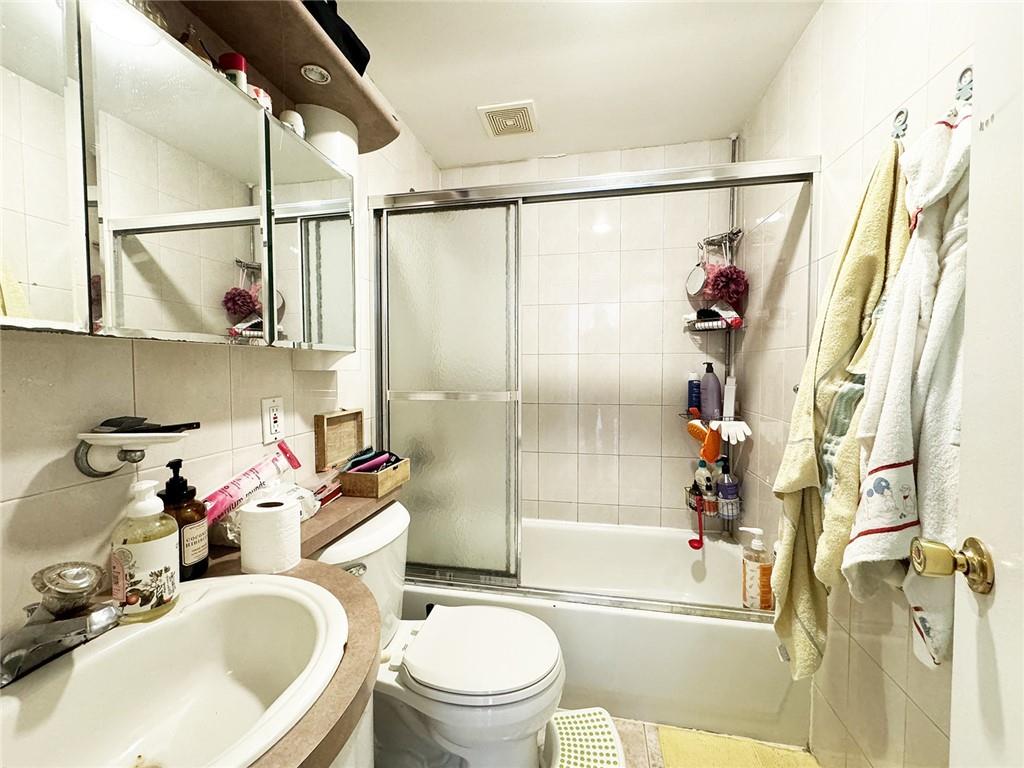 249 Bay 22nd Street Brooklyn, NY 11214 - Photo 11 of 12 a bathroom with a sink toilet and shower