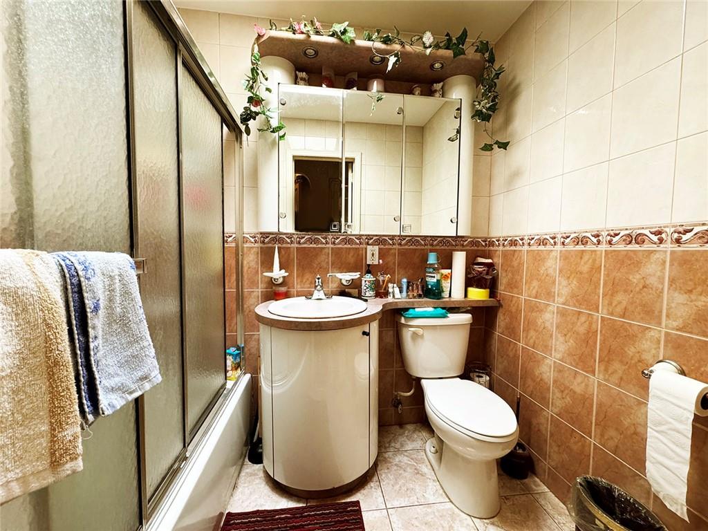 249 Bay 22nd Street Brooklyn, NY 11214 - Photo 5 of 12 a bathroom with a sink mirror vanity and toilet